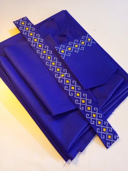Blue fabric with detailed white and gold embroidered pattern