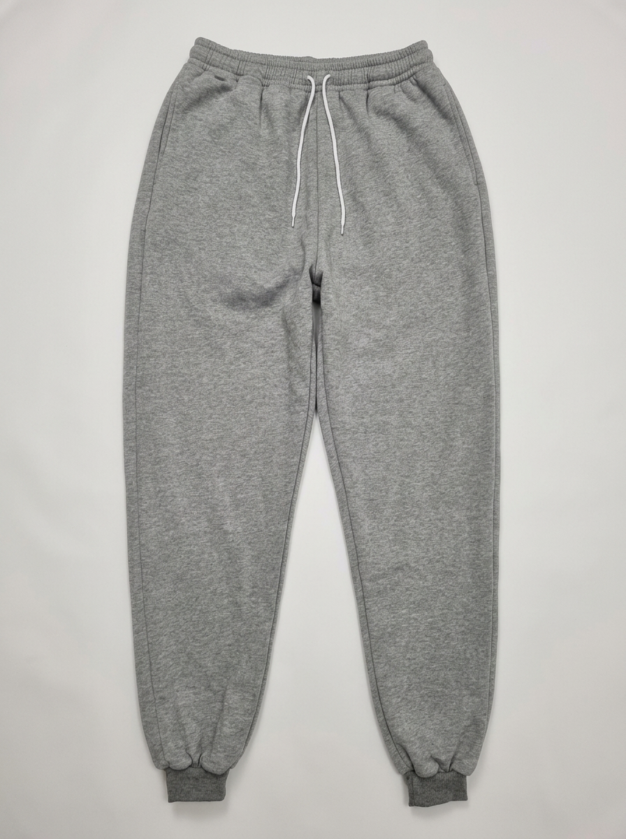 Grey cuffed joggers produced by Sejeta on a clean background